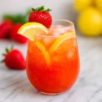 Homemade strawberry lemonade recipe in glass pitcher with fresh fruit
